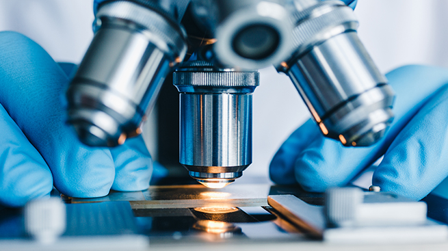 Close-up shot of microscope with metal lens at laboratory.